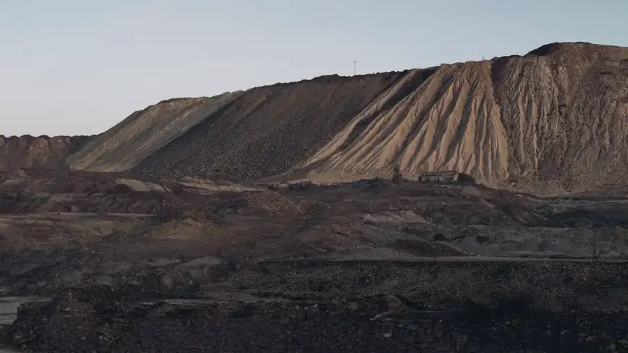 Pilha de minério de grande porte, com as marcas de basculamento na encosta